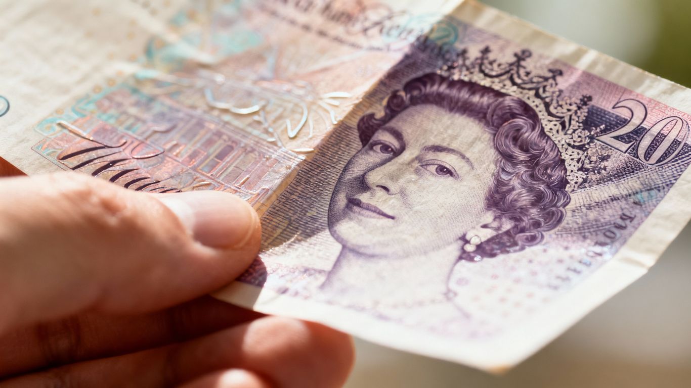 UK pound sterling banknote held in hand.